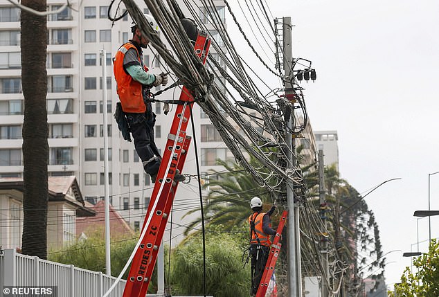 يتفقد العمال من شركة الكهرباء المحلية خطوط الطاقة خلال تعتيم في مدينة فينيا ديل مار في منتجع التشيلي